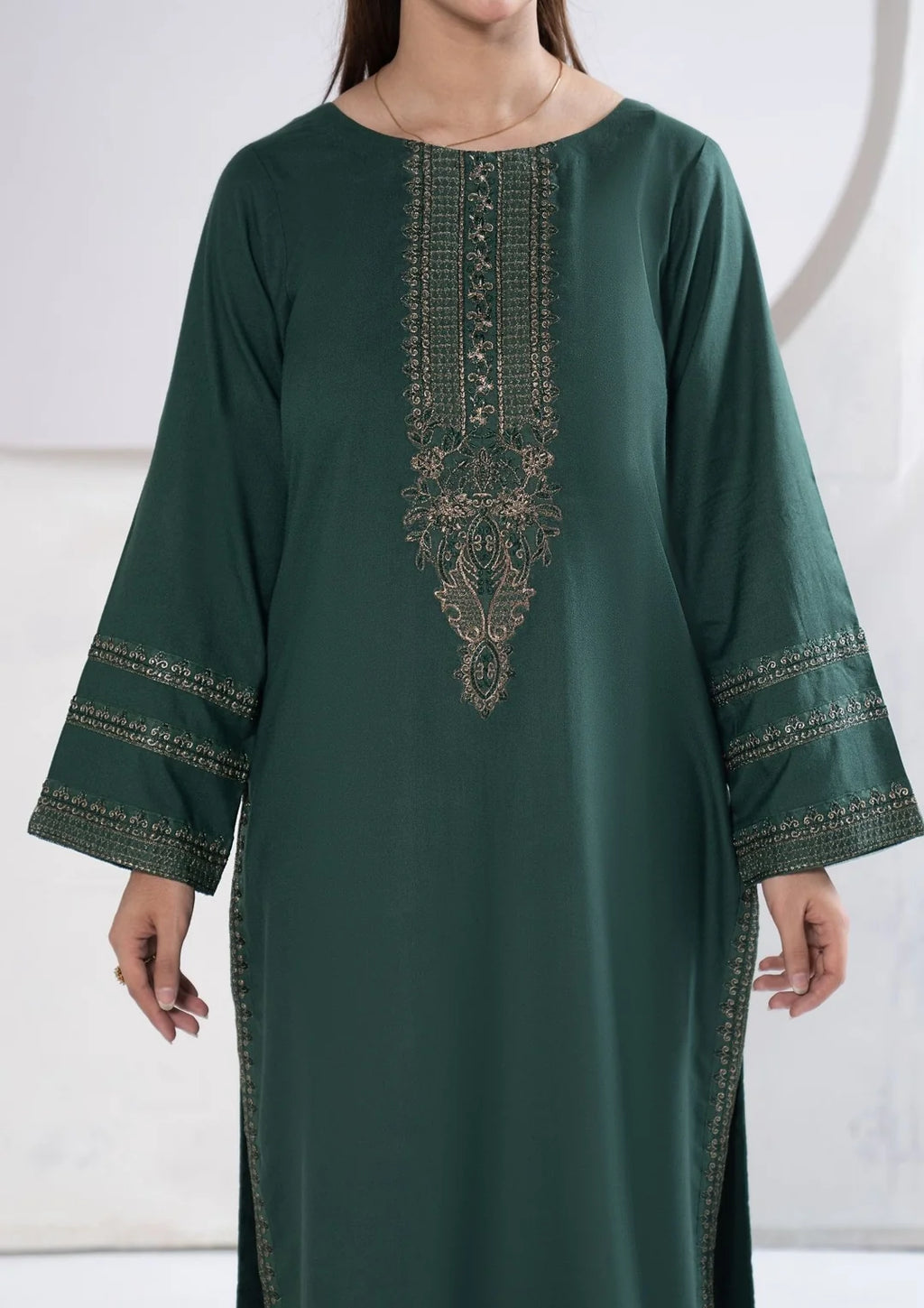 Close-up of embroidered sleeve bands on deep green shirt