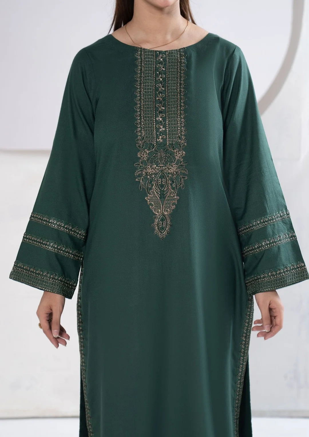 Close-up of embroidered sleeve bands on deep green shirt