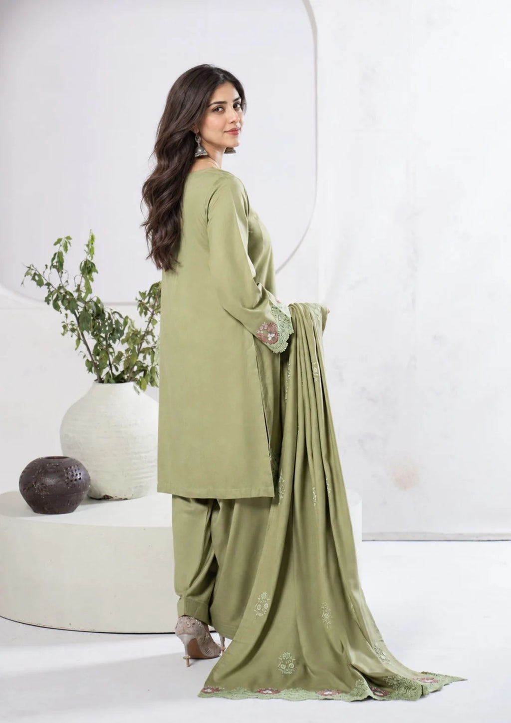 Front detail of green embroidered neckline and sleeve cuffs