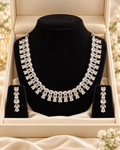 Silver-colour necklace with teardrop-shaped clear stones and matching drop earrings in display box